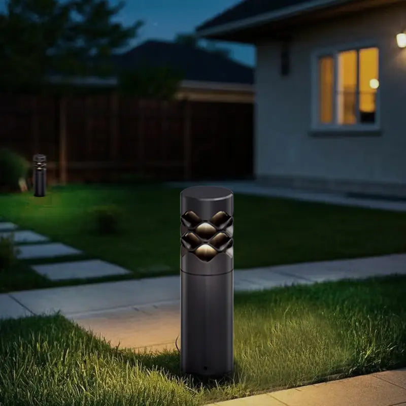 Next to the gravel path in the courtyard, there is a black lawn lamp with diamond decorations, surrounded by green plants.