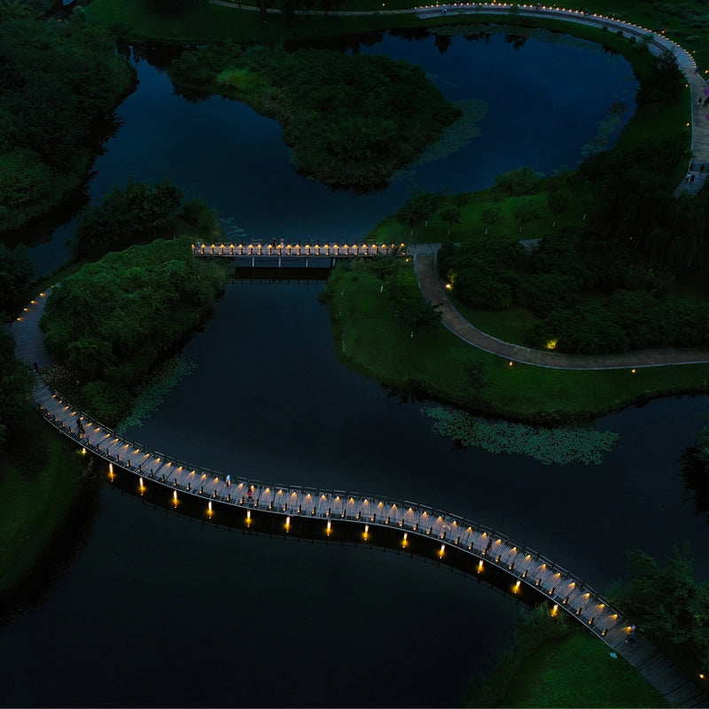 Looking down from the air, the winding road decorated with Low Profile Outdoor Path Light has a unique atmosphere at night.