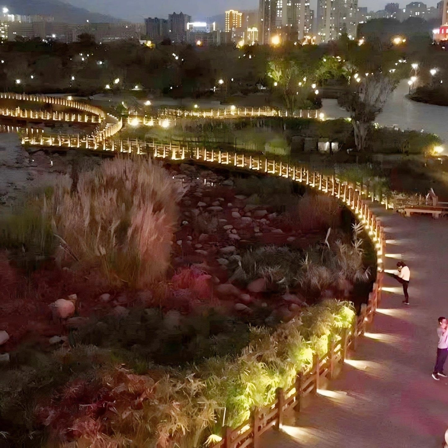 On the road between the park lakes, many small arc-shaped path lights are lit up, which is very atmospheric.