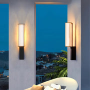 Two wall lamps illuminate the balcony, each fixed to a separate column.
