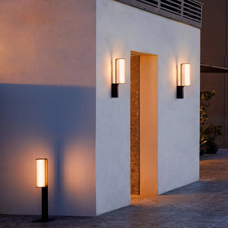 A pair of wall lamps frame the entrance, complemented by a low-profile outdoor light at the corner.