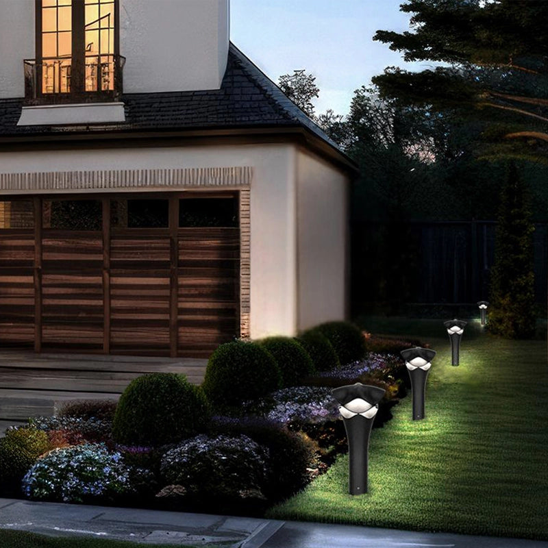 In the courtyard under the night sky, two unique Ruee lawn lamps stand quietly. The warm yellow light shines through the lamp body, gently illuminating the surrounding green plants.