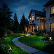 In the courtyard, a neatly trimmed lawn stretches out in lush green. Along both sides, sleek lawn lights cast a warm golden glow, gently illuminating the surrounding plants. In the background, trees and wooden fencing add to the natural ambiance, creating a tranquil, stylish, and inviting outdoor living space.