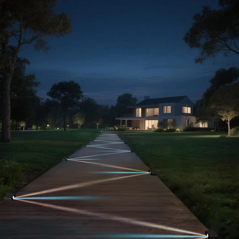 The outdoor scene at night, a wooden path is illuminated by lights on both sides, and the lights project geometric patterns on the ground, leading to a modern-style house surrounded by green trees and grass, creating a peaceful and warm atmosphere.